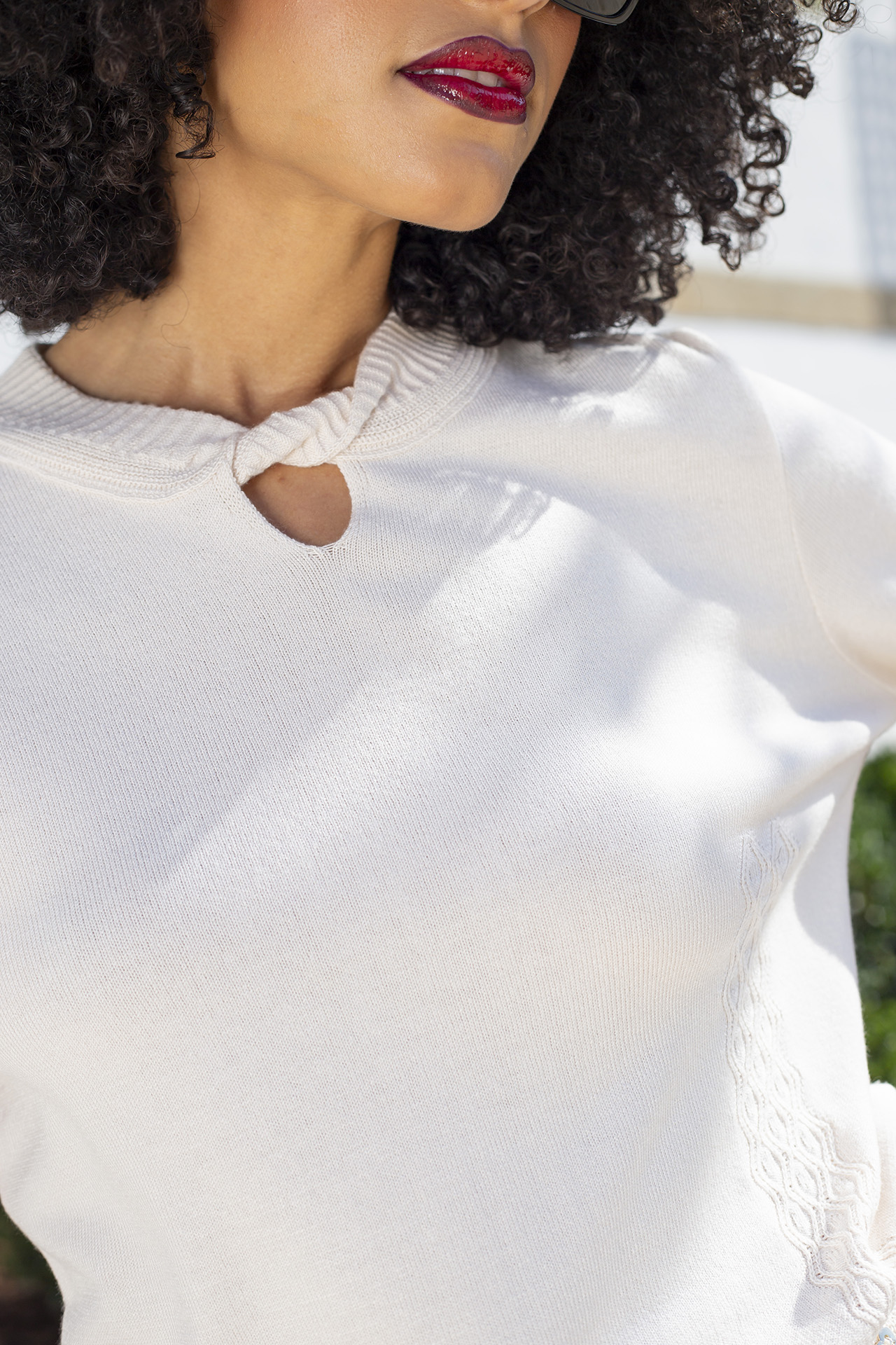 Knitted jumper with twisted collar